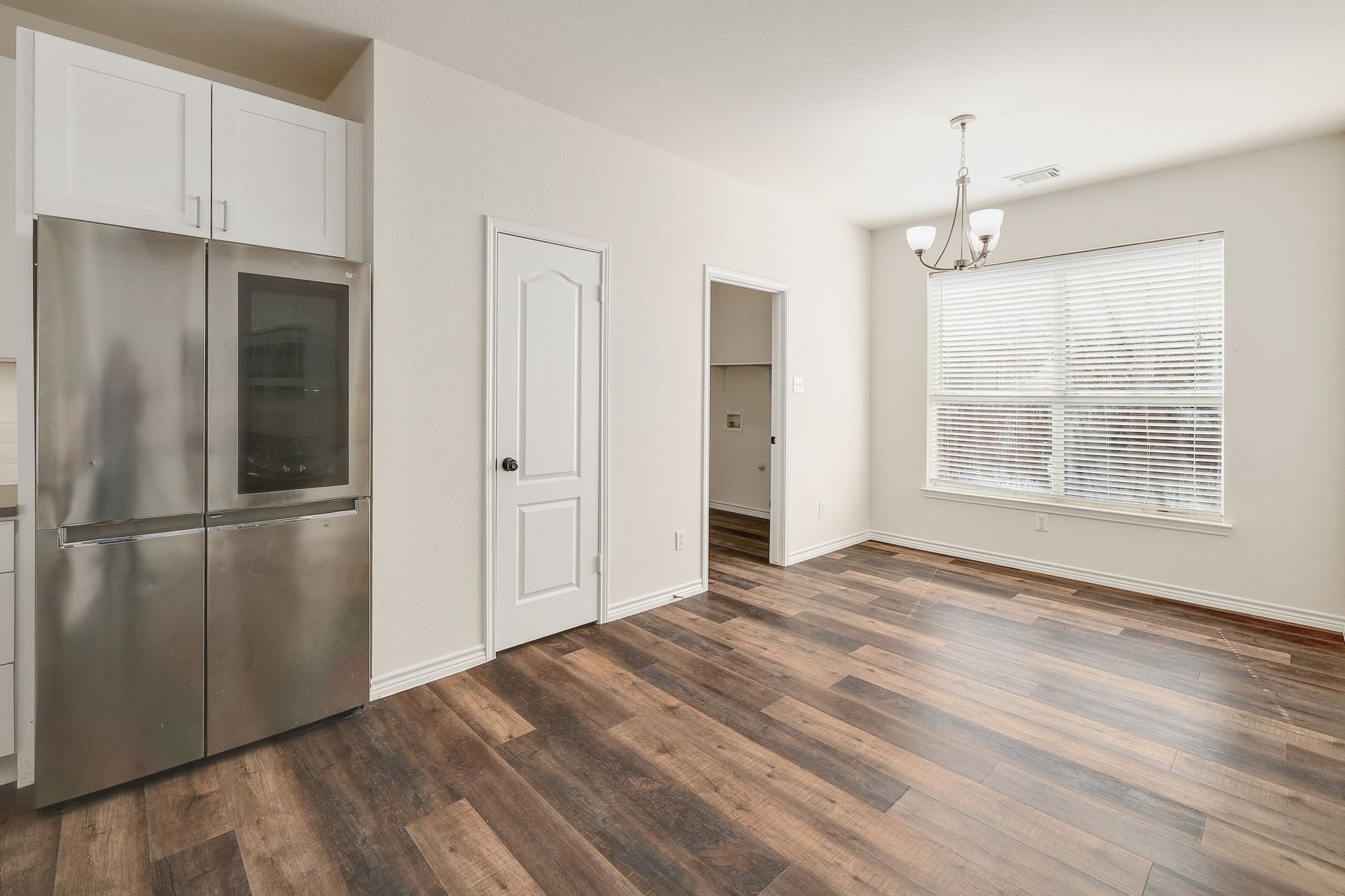 2307 Hayfield Square Pflugerville, TX 78660 - Photo 15 of 40 a view of an empty room with wooden floor and a window
