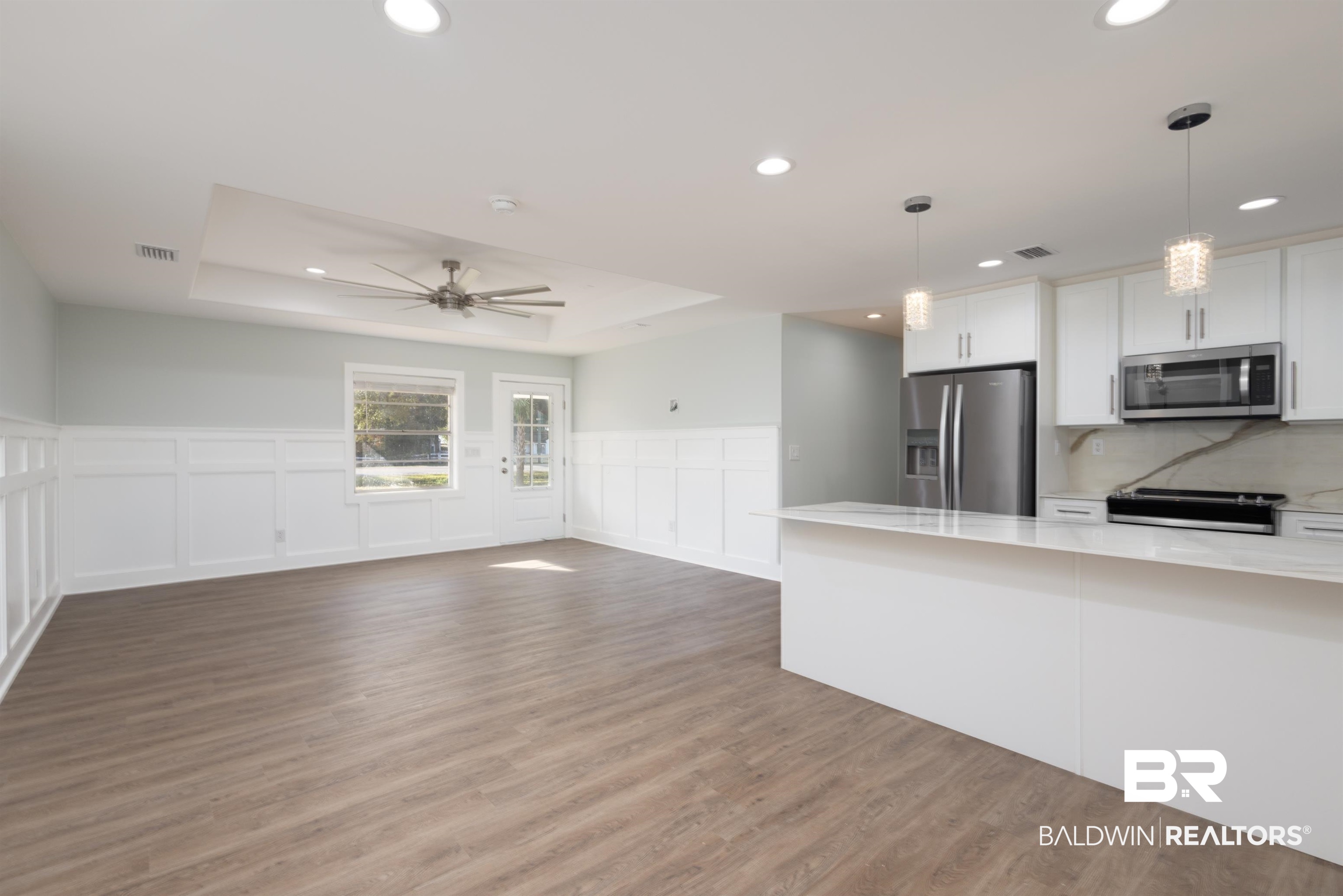 18267 Highway 98 Foley, AL 36535 - Photo 4 of 26 Kitchen with a tray ceiling, white cabinetry, a decorative wall, pendant lighting, and stainless steel appliances