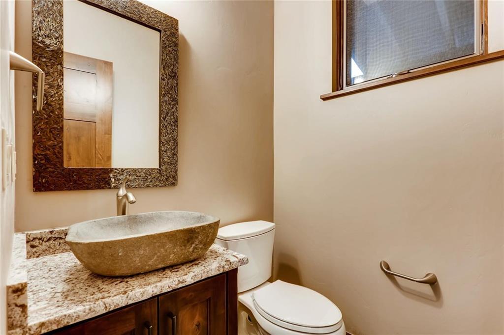 202 Cucumber Creek Road Breckenridge, CO 80424 - Photo 18 of 28 a bathroom with a granite countertop toilet sink and mirror
