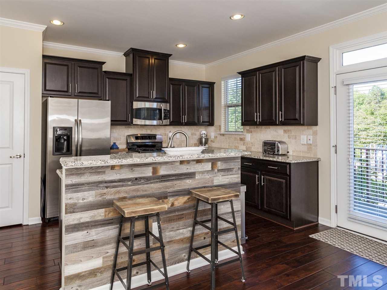 1310 Cornell Place Raleigh, NC 27607 - Photo 4 of 25 a kitchen with kitchen island granite countertop wooden cabinets and refrigerator stove a sink and dishwasher