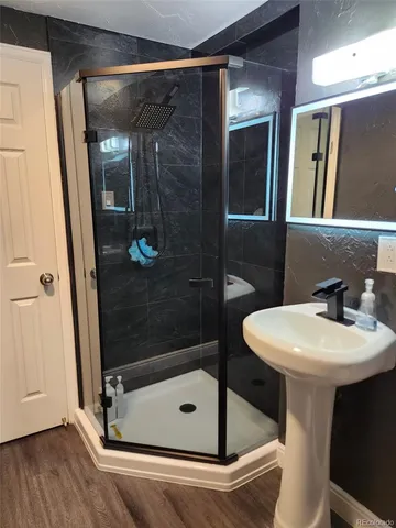 a bathroom with a sink mirror and shower