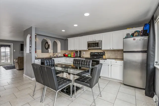 a kitchen with stainless steel appliances granite countertop a refrigerator and a stove top oven