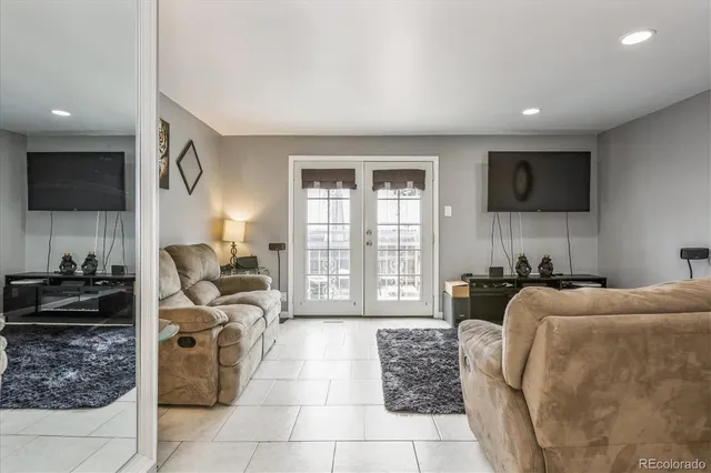 a living room with furniture a flat screen tv and a floor to ceiling window