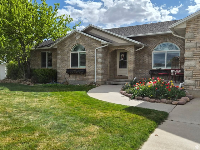 1697 West 2450 Vernal, UT 84078 - Photo 1 of 36 View of front of house with a front yard, brick siding, and a shingled roof