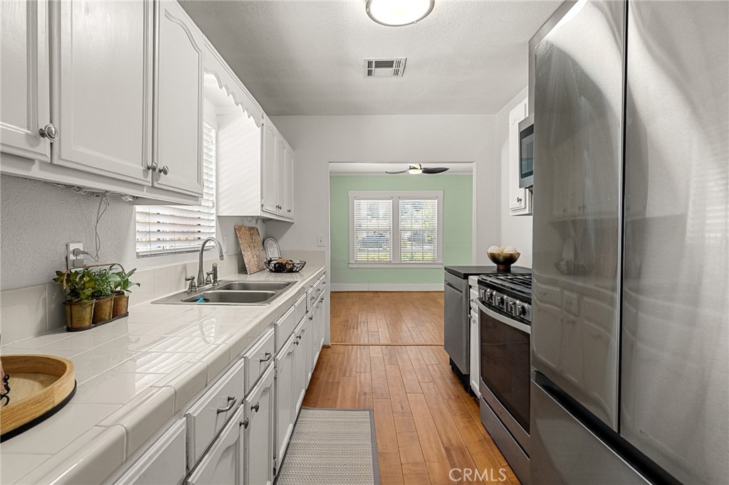 4390 Edgewood Place Riverside, CA 92506 - Photo 12 of 32 a kitchen with a sink stove and refrigerator
