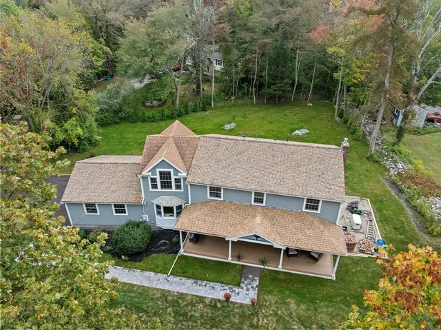 aerial view of a house with a big yard and large trees