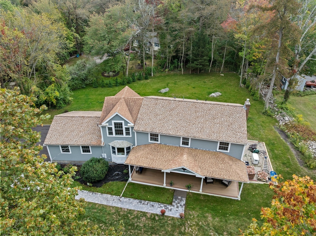 aerial view of a house with a big yard and large trees