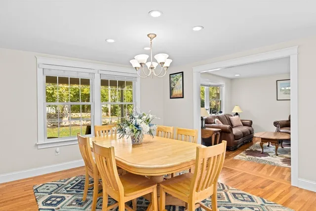 a view of a dining room with furniture a chandelier and wooden floor