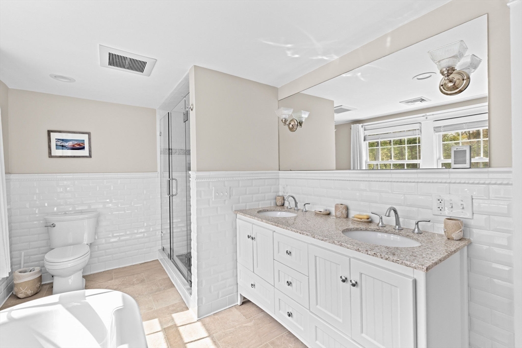355 Tilden Road Scituate, MA 02066 - Photo 31 of 42 a spacious bathroom with a granite countertop toilet sink and mirror