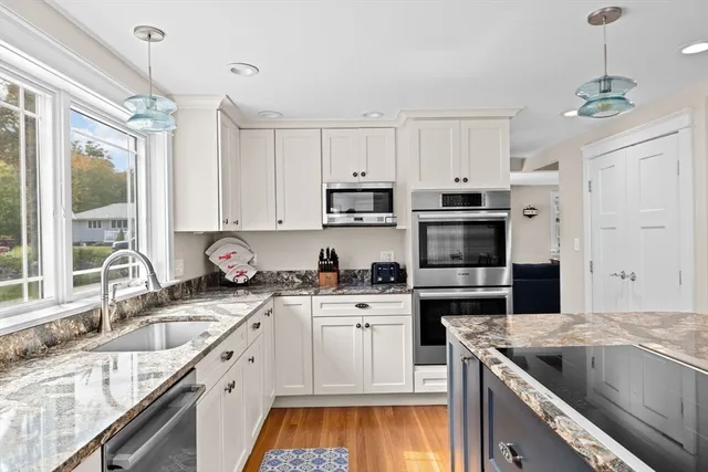 a kitchen with stainless steel appliances granite countertop a sink stove and refrigerator