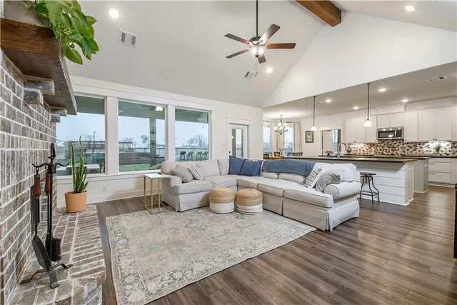 a living room with fireplace furniture and a large window
