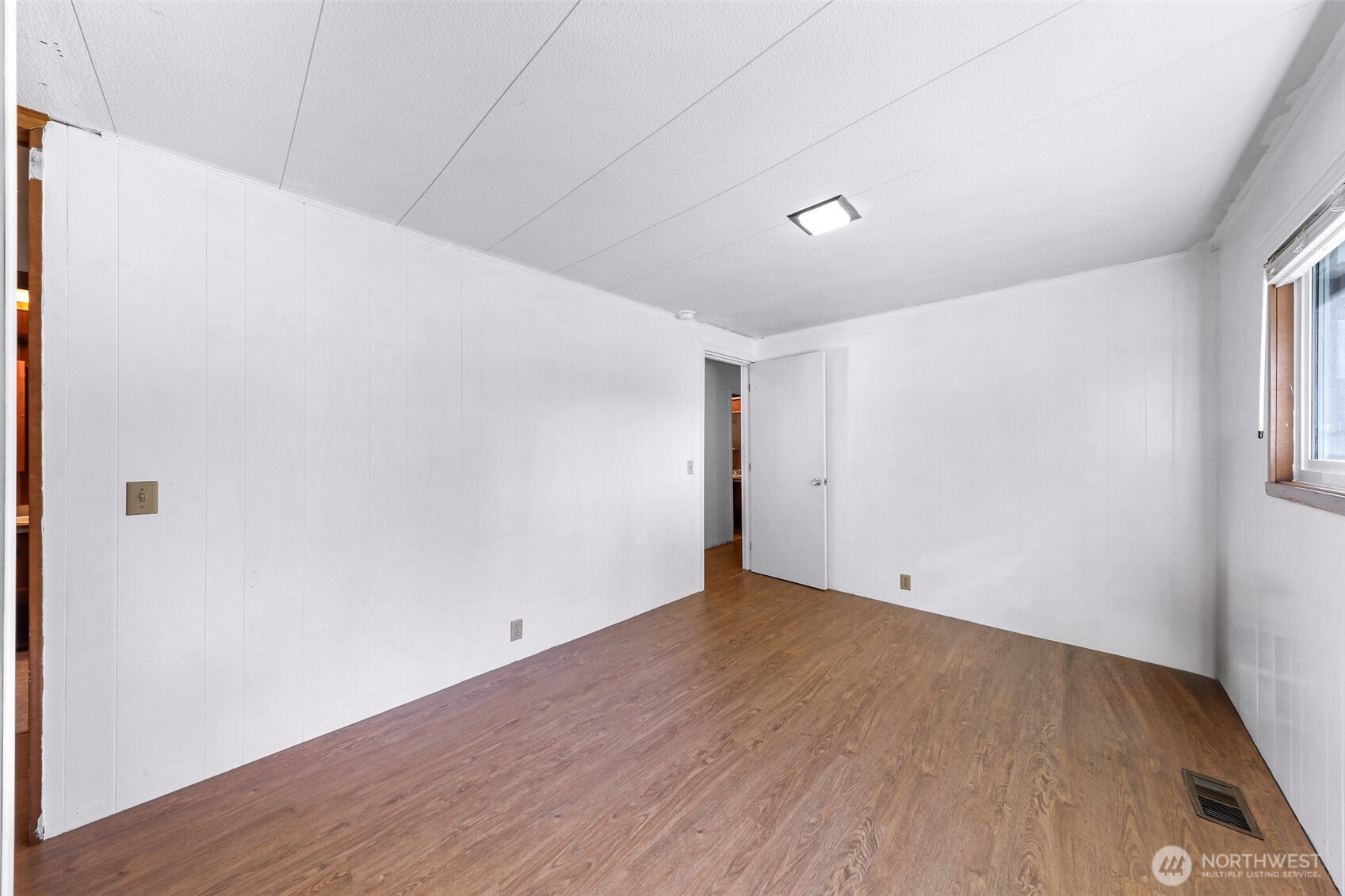 9403 Pierce Lane, Unit 1 Sedro-Woolley, WA 98284 - Photo 19 of 30 a view of an empty room with wooden floor and a window