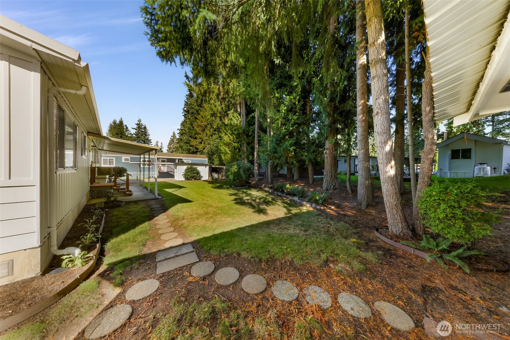 9403 Pierce Lane, Unit 1 Sedro-Woolley, WA 98284 - Photo 29 of 30 a view of a street that has large trees and a wooden fence