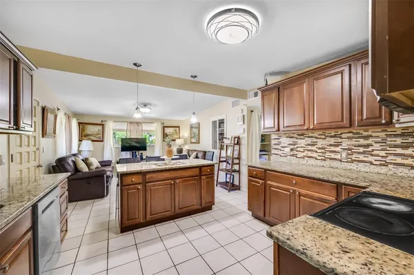 a kitchen with stainless steel appliances granite countertop a sink counter space cabinets and a stove