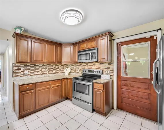 a kitchen with stainless steel appliances granite countertop a stove sink and cabinets