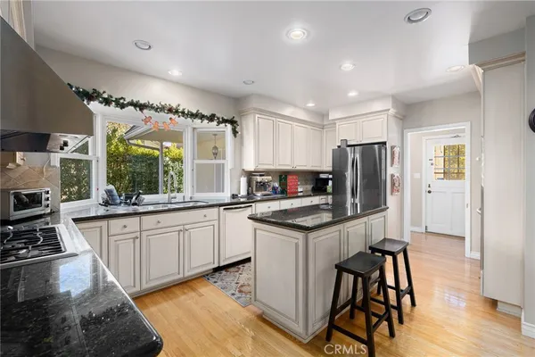 a kitchen with granite countertop a sink stainless steel appliances and cabinets