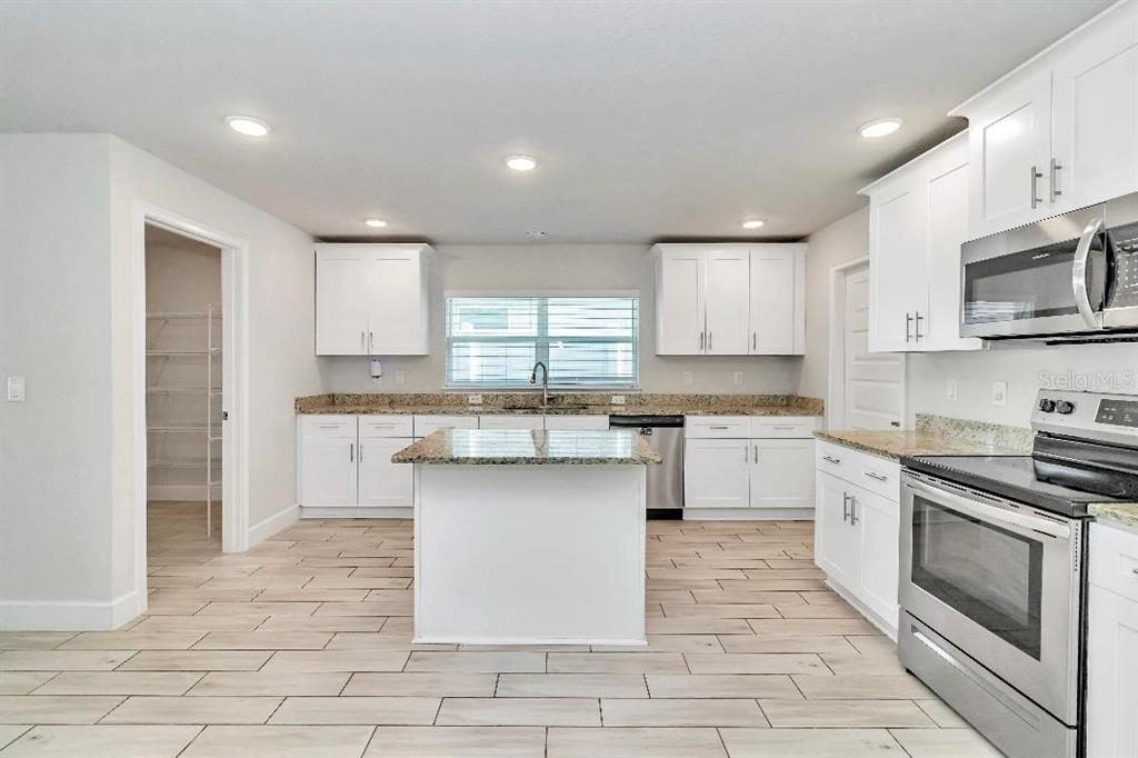 8376 Southwest 59th Terrace Ocala, FL 34476 - Photo 6 of 23 a kitchen with stainless steel appliances granite countertop a stove a sink and a microwave