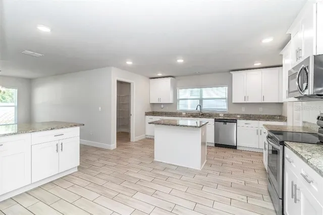 a kitchen with a sink window and cabinets