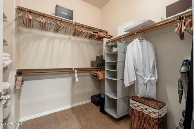 a bedroom with a bed a chandelier and a window