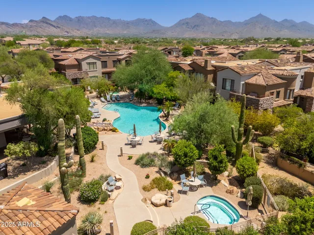 a view of a swimming pool with lawn chairs and a big yard