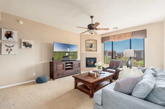 a living room with furniture a fireplace and a chandelier