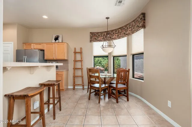 a kitchen with a sink window and chairs
