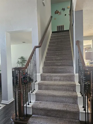 a view of staircase with wooden floor and a chandelier