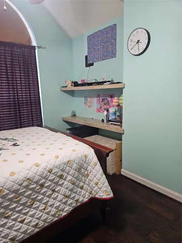 a bedroom with a bed and painting on the wall