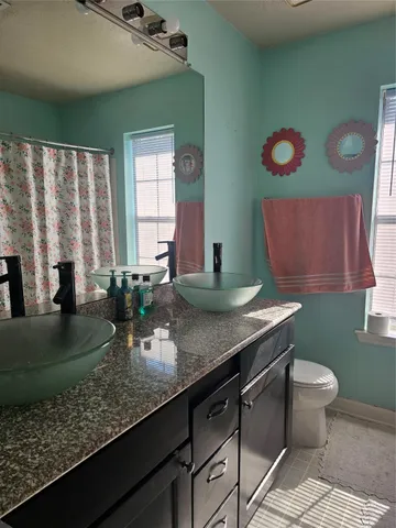 a bathroom with a granite countertop sink and a large mirror
