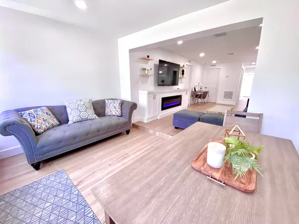 a living room with furniture and a kitchen view