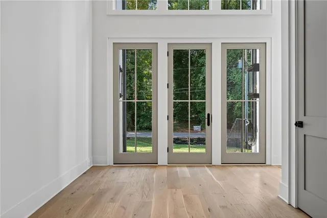 an empty room with floor to ceiling windows and plants