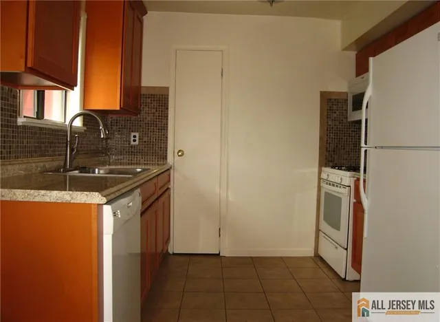 a kitchen with a sink a refrigerator freezer a washer and dryer