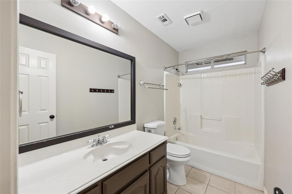 828 Rockefeller Lane Allen, TX 75002 - Photo 21 of 31 a bathroom with a granite countertop sink toilet a large mirror a shower and vanity
