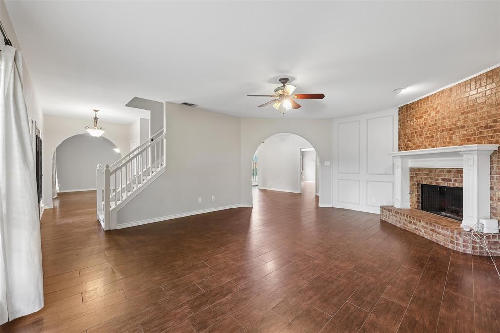 828 Rockefeller Lane Allen, TX 75002 - Photo 5 of 31 a view of an empty room with wooden floor and a fireplace