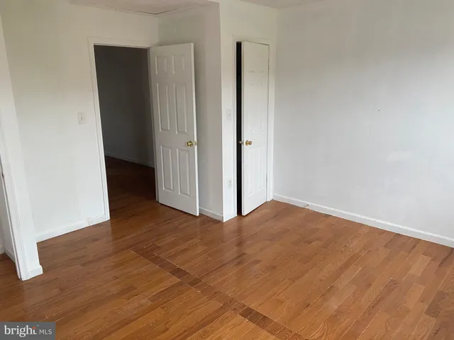 a view of an empty room with closet and a window