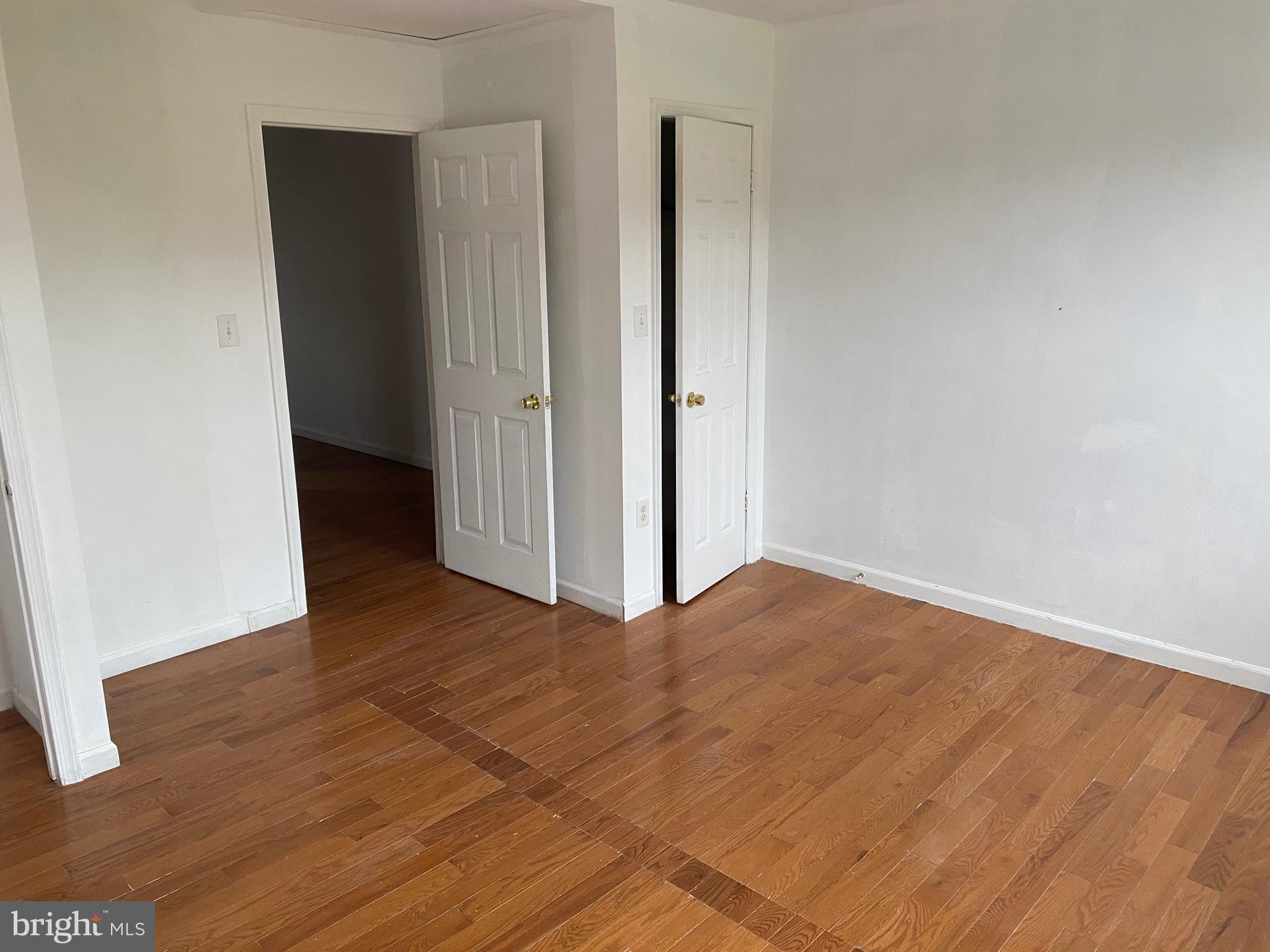 a view of an empty room with closet and a window