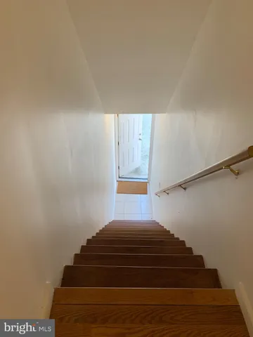 a view of an empty room with wooden floor and windows