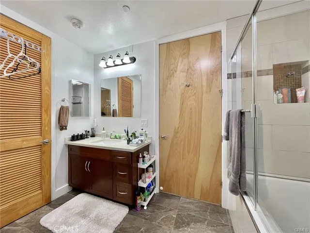 a bathroom with a double vanity sink a mirror and a shower