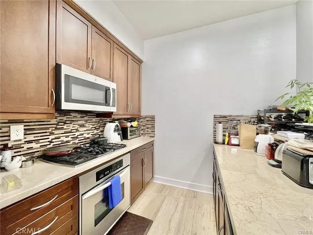 a kitchen with stainless steel appliances granite countertop a sink stove and cabinets