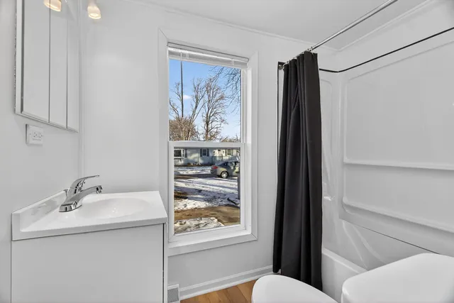 a bathroom with a sink a toilet and shower