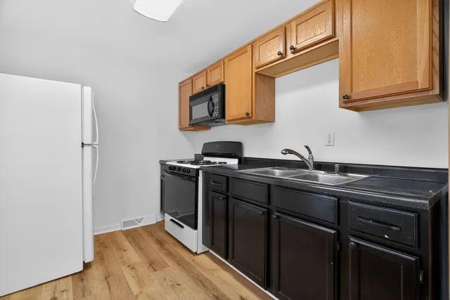 a kitchen with stainless steel appliances granite countertop a sink stove and microwave
