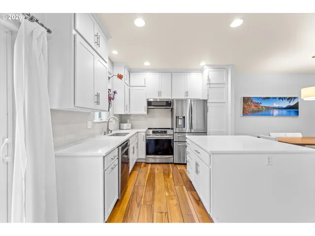 a kitchen with a sink a counter top stainless steel appliances and cabinets