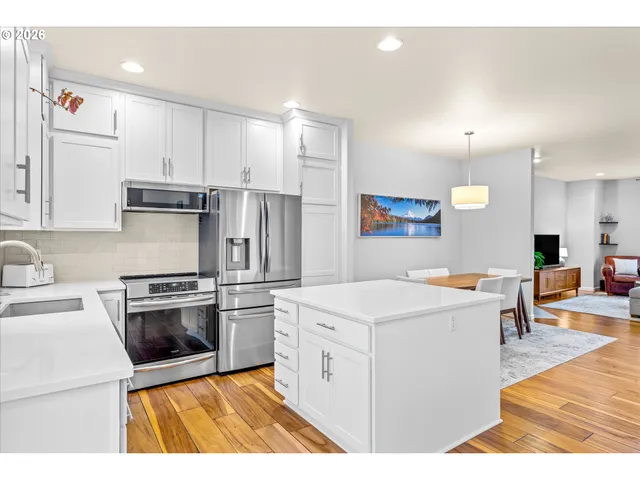 a kitchen that has a sink a stove and chairs