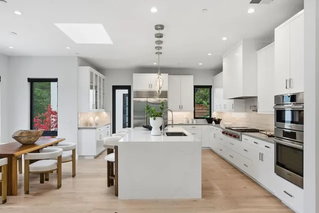 a kitchen with a white cabinets and wooden floor