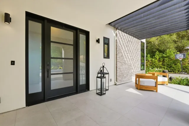 a view of a patio with couches table and chairs with wooden floor and fence