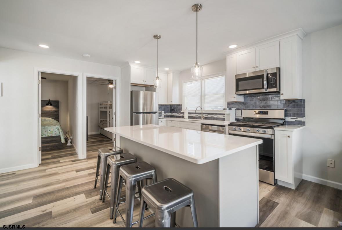 207 13th Street North Brigantine, NJ 08203 - Photo 12 of 44 a kitchen with kitchen island stainless steel appliances a stove a sink and a refrigerator