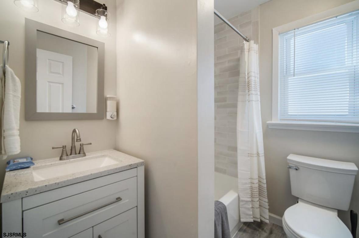 207 13th Street North Brigantine, NJ 08203 - Photo 15 of 44 a bathroom with a toilet sink vanity and mirror