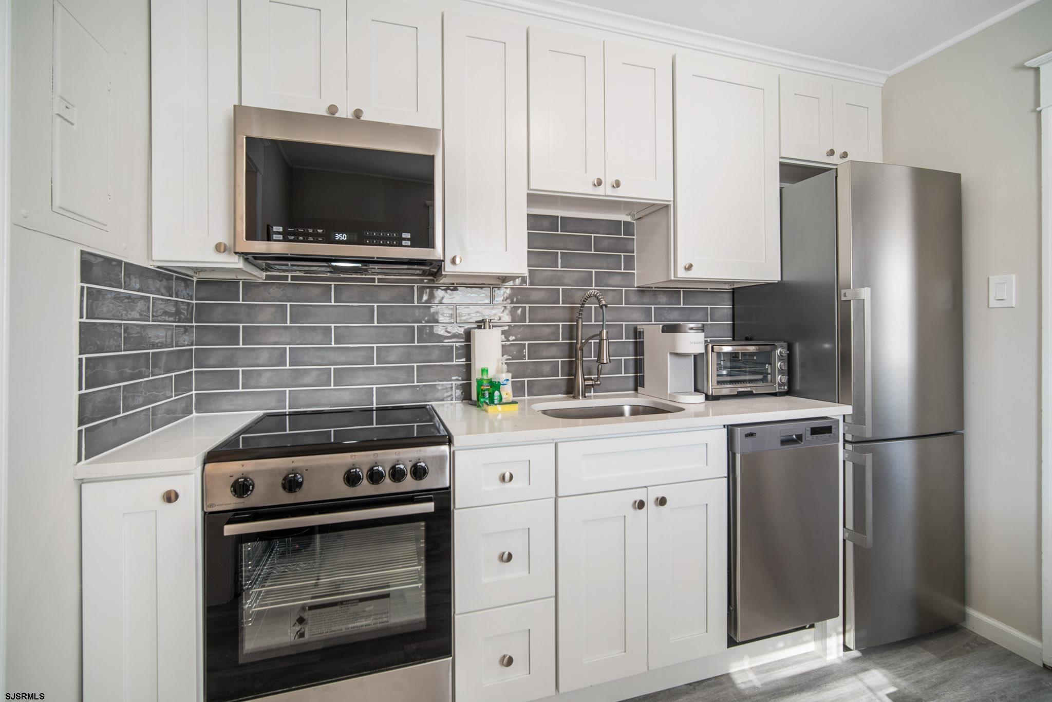 207 13th Street North Brigantine, NJ 08203 - Photo 25 of 44 a kitchen with cabinets stainless steel appliances and a counter space
