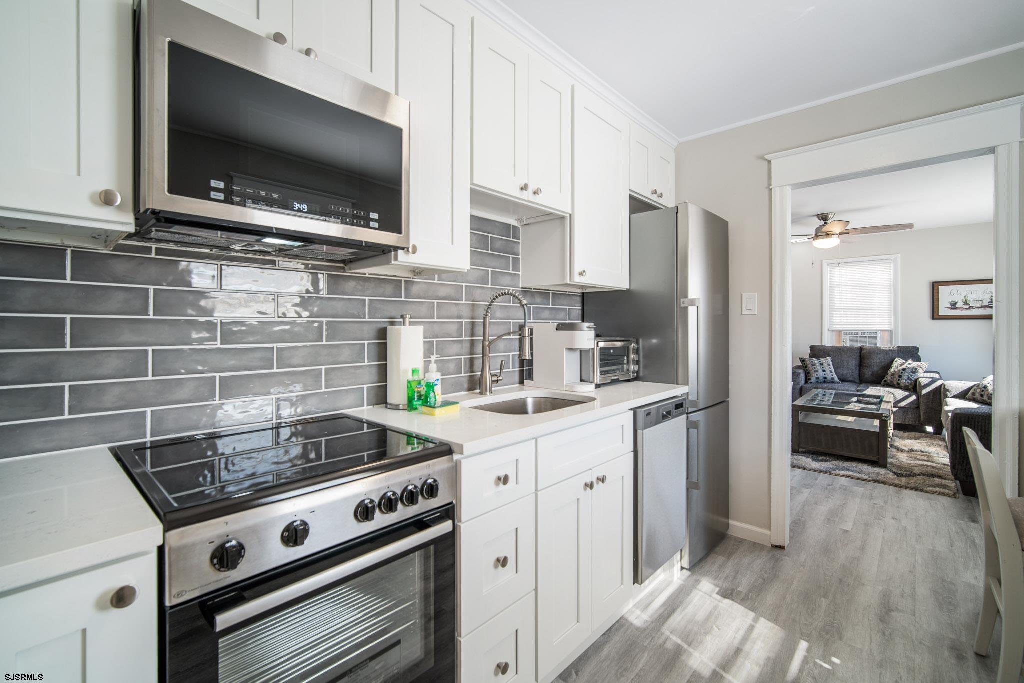 207 13th Street North Brigantine, NJ 08203 - Photo 26 of 44 a kitchen with stainless steel appliances a stove a sink and a microwave