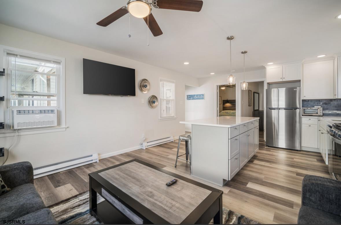 207 13th Street North Brigantine, NJ 08203 - Photo 6 of 44 a living room with stainless steel appliances kitchen island furniture and a flat screen tv
